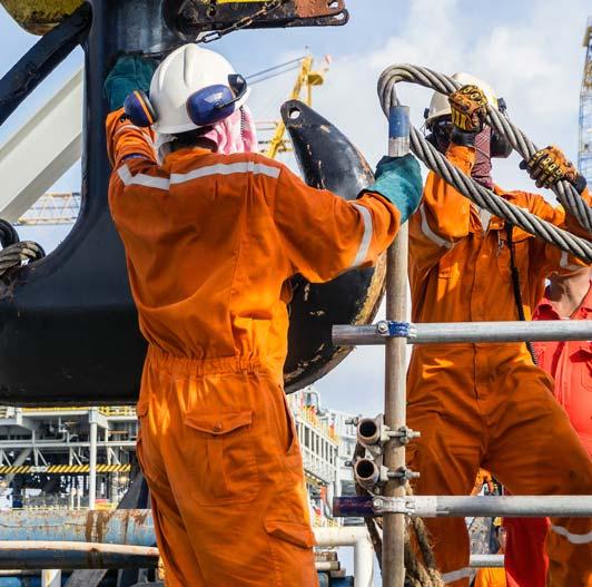 men attaching steel rope to hook